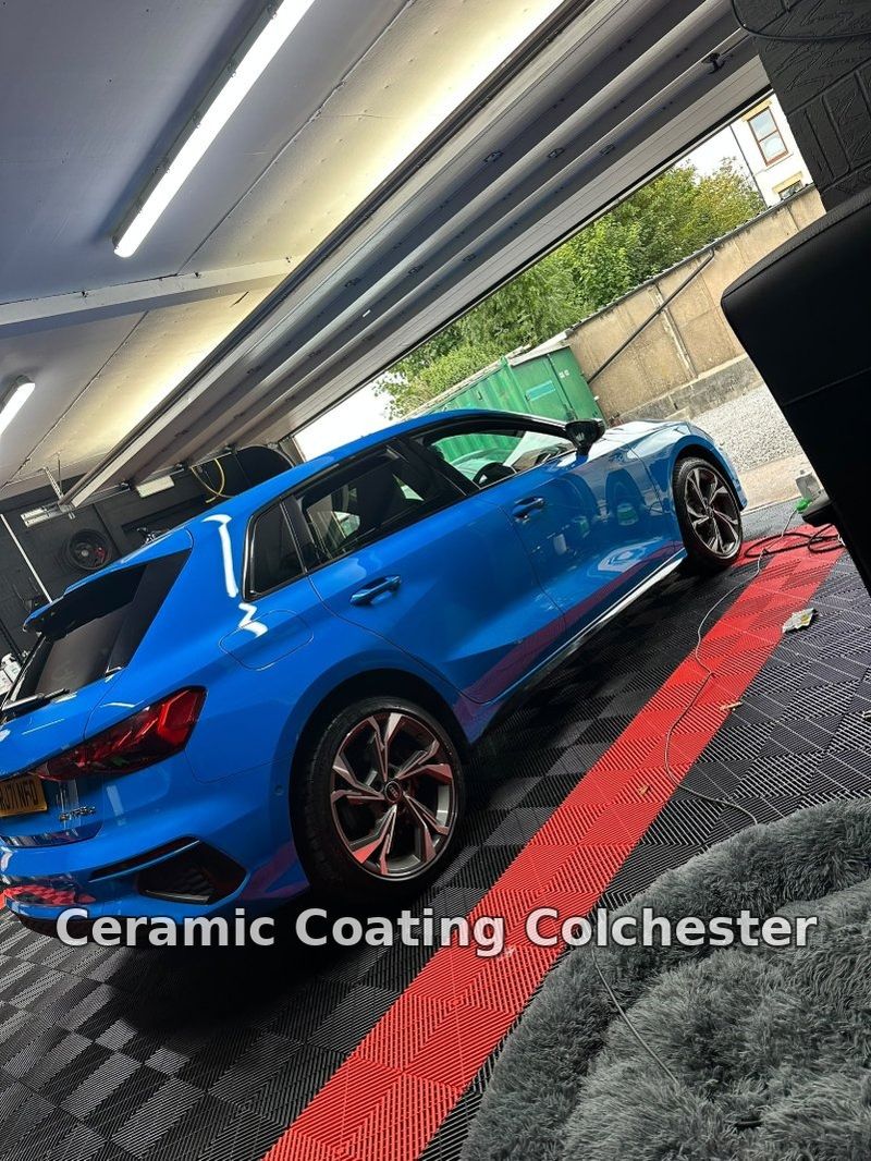 Blue Audi S3 inside a detailing studio under bright lighting